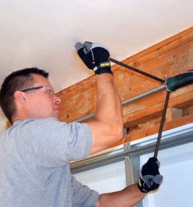 man changing garage door springs